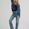 model wearing classic straight leg jeans with medium gritty wash with distressing on the knees
