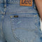 back view of model wearing classic straight leg jeans with medium gritty wash with distressing on the knees