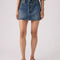 up close of model wearing medium blue mini denim skirt with pin tucked denim blouse