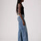 side view of model wearing light denim low loose jeans