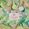 colorful green, blue, and tan swirl heart shaped eye pillow with matching print background