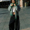 model wearing kelly green and pink striped cardigan with gold bow buttons with matching bonnet and scarf