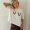 model wearing white cropped relaxed fit tee with black horseshoes on the bust