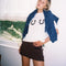 model wearing white cropped relaxed fit tee with black horseshoes on the bust