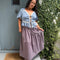 model wearing brown striped midi skirt with asymmetrical detail on the waist 