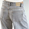 up close of back of light grey low rise wide leg denim and white tank