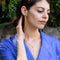 model wearing gold star earrings with gold chains coming from the back