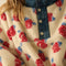 up close of model wearing white sherpa half zip with denim trim and collar and red floral print