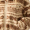 up close of model wearing cropped white zip up jacket with brown alpine print