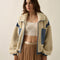 model wearing cream sherpa zip-up jacket with blue denim trim with a high neck collar