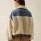 back view of model wearing cream sherpa zip-up jacket with blue denim trim with a high neck collar