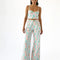model wearing pastel wavy print bottoms with button closure and flared legs and matching bustier top