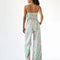 back view of model wearing pastel wavy print bottoms with button closure and flared legs and matching bustier top