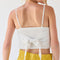 back view of model wearing white handkerchief tank with eyelet floral detail and tie detail