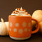 orange ceramic mug with floral border design with a yummy drink inside