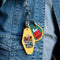 model wearing dark green patch keychain with snoopy on his doghouse looking up at a flower