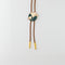 gold ginkgo bolo tie with brown cord and gold tips