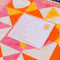 fabric and instruction card of pink, red, cream, and orange heart patchwork kit