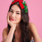 model wearing green tinsel headband with red velvet bow and ornaments