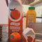 model setting up a table with orange juice vase and orange juice salt and pepper shakers