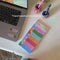 model writing their packed schedule on colorful weekly plan notepad