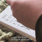 model putting  colorful circle and smiley square bookplates with 'from the library of" and 'this book belongs to' on a book