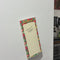model writing notes on fruit themed shopping list pad