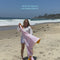 model waving 'always better together' towel in the wind on the beach