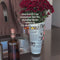 model putting red flowers in rolled newspaper vase