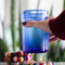set of 4 colorful pom coasters with a cup on it