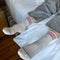 model wearing pair of white socks with red and blue stripe accents